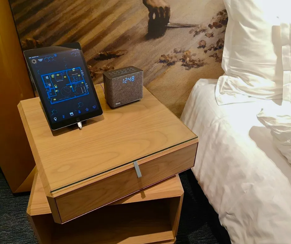iPad de pilotage mySmartJarvis et enceinte connectée sur la table de chevet