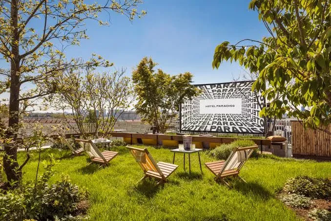Chambre avec écran de projection affichant l'identité Hôtel Paradiso, fauteuil rouge et pop-corn